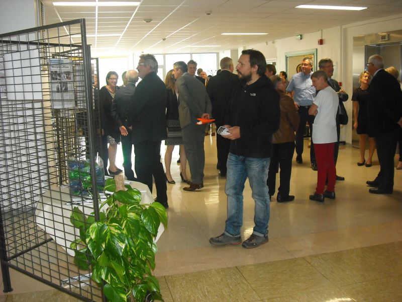 Les invités réunis sur le palier du premier étage devant l’exposition photos